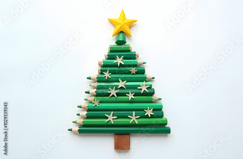  creative Christmas tree made of green pencils on a white background, a yellow star made of shavings on the top.Christmas and New Year flat lay