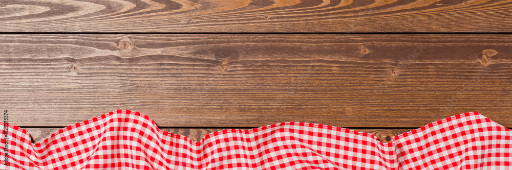 Red folded tablecloth on an old wooden table. Close up Red folded tablecloth on an old wooden table. Close up