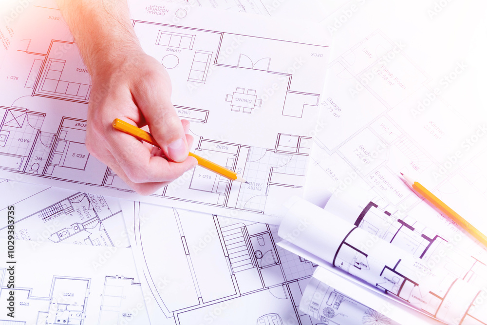 Builder's hands on the background of a house plan. Construction planning. Drawing up an estimate.. Builder's hands on the background of a house plan. Construction planning. Drawing up an estimate..