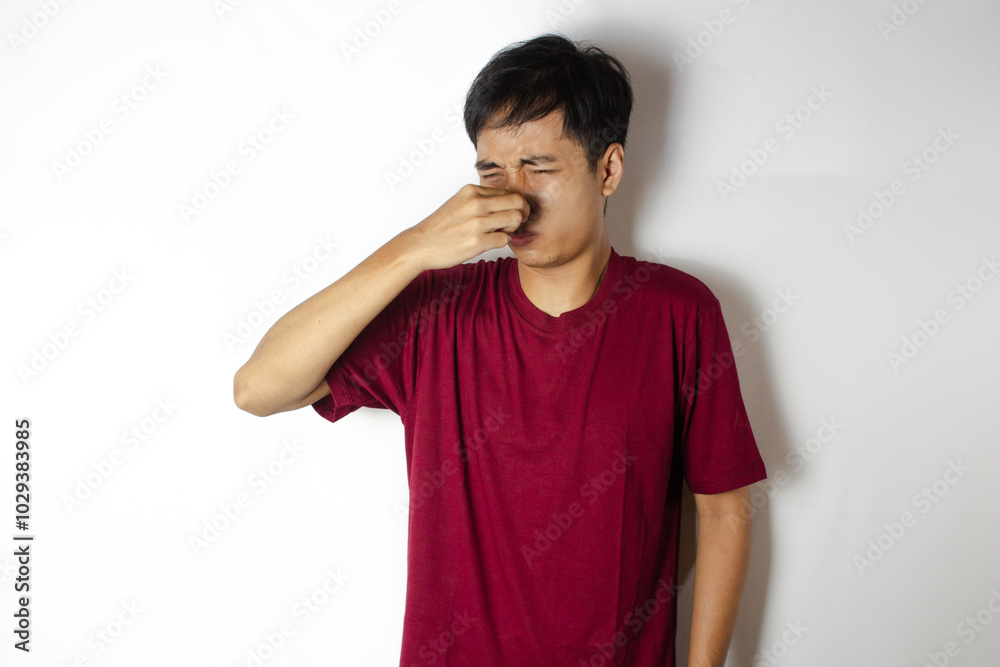 teenager covering his nose from the pungent smell teenager covering his nose from the pungent smell