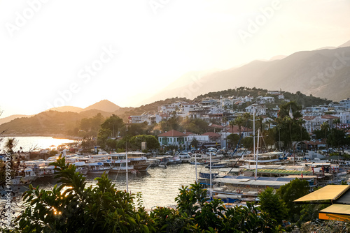 Fototapeta Naklejka Na Ścianę i Meble -  Sunset in Kas, Antalya district, Turkiye. Charming sunset view of the seaside resort town of Kas in Turkey. Romantic waterfront promenade and port with yachts and boats view. Spectacular sunset