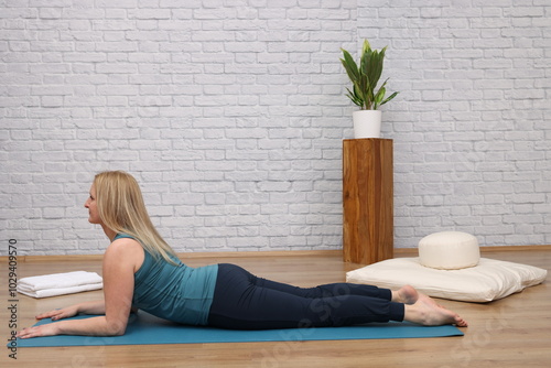Woman doing yoga in yoga studio - Half Cobra