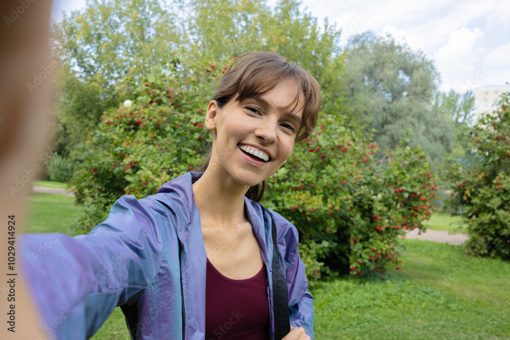 Beautiful fit brunette with a big smile taking selfie in nature during hiking Beautiful fit brunette with a big smile taking selfie in nature during hiking