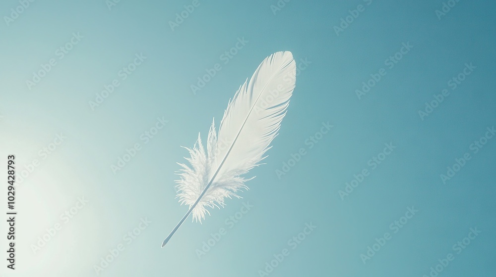 Obraz premium A white feather drifting against a clear blue sky with the golden sun overhead