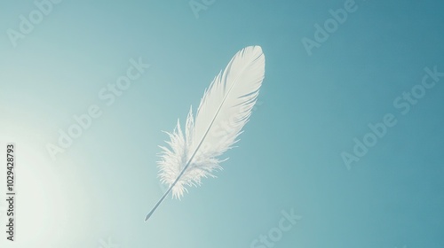  A white feather drifting against a clear blue sky with the golden sun overhead