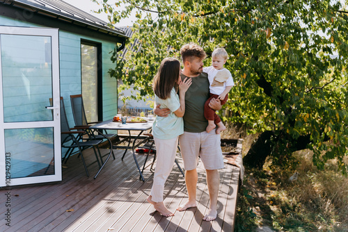 Happy family enjoying a peaceful outdoor moment on a wooden deck, surrounded by nature and sunshine photo