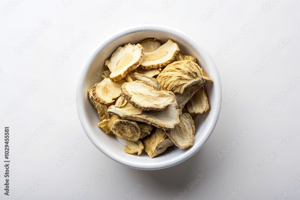 Sliced angelica root in white bowl from above on white background Sliced angelica root in white bowl from above on white background