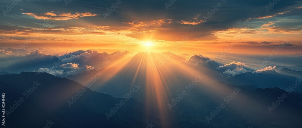Golden rays of sunlight burst through clouds over majestic mountain peaks at sunset. Golden rays of sunlight burst through clouds over majestic mountain peaks at sunset.