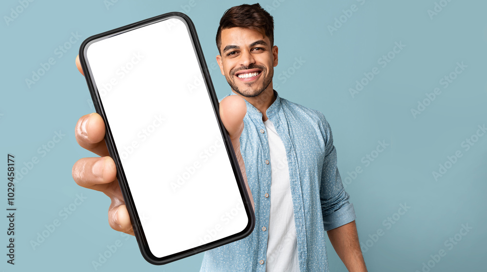 Smiling Handsome Arab Guy In Casual Showing Mobile Phone With White Blank Screen For Advertisement, Recommending Mobile Dating Application, Panorama With Free Space, Mockup, Colllage Smiling Handsome Arab Guy In Casual Showing Mobile Phone With White Blank Screen For Advertisement, Recommending Mobile Dating Application, Panorama With Free Space, Mockup, Colllage