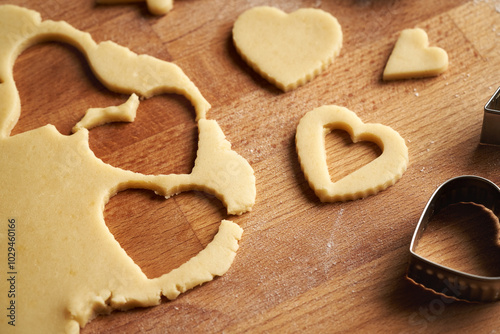Heart shapes cut out from rolled out dough to prepare traditional Linzer Christmas cookies