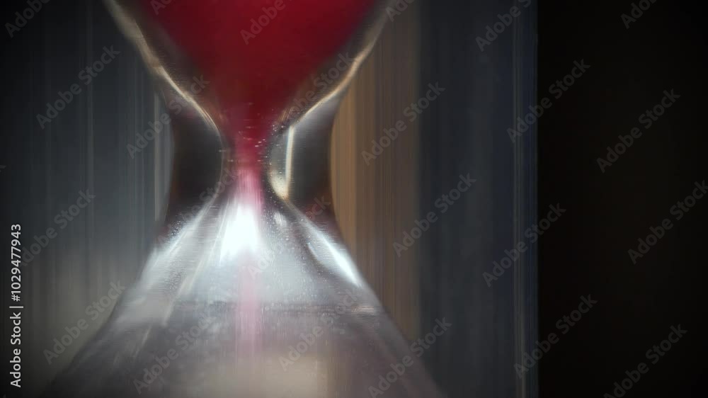 Red sand in hourglass. Time flows backwards, in the opposite direction. Time is like sand in the endless desert, but remember, your handful is in hourglass. 4K 60fps macro shot reverse time video