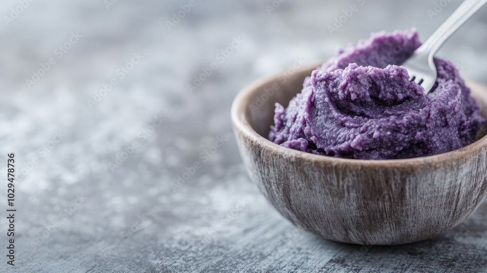 A beautifully crafted wooden bowl filled with smooth purple mashed potato and a fork resting on top, capturing a sense of homely comfort and culinary creativity. A beautifully crafted wooden bowl filled with smooth purple mashed potato and a fork resting on top, capturing a sense of homely comfort and culinary creativity.