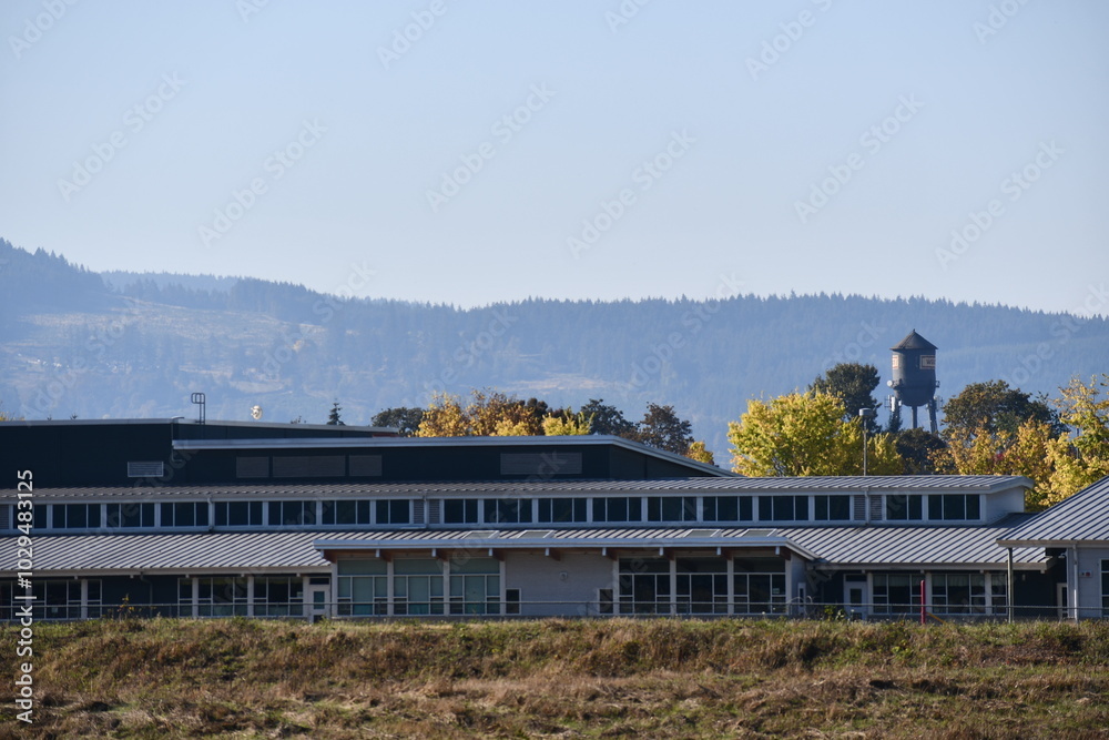 Modern day school building. Lots of big windows and natural light. Water tower in the horizon. Modern day school building. Lots of big windows and natural light. Water tower in the horizon.
