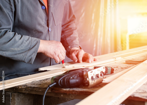 Measuring wooden slot and key boards and drawing with pencil line photo