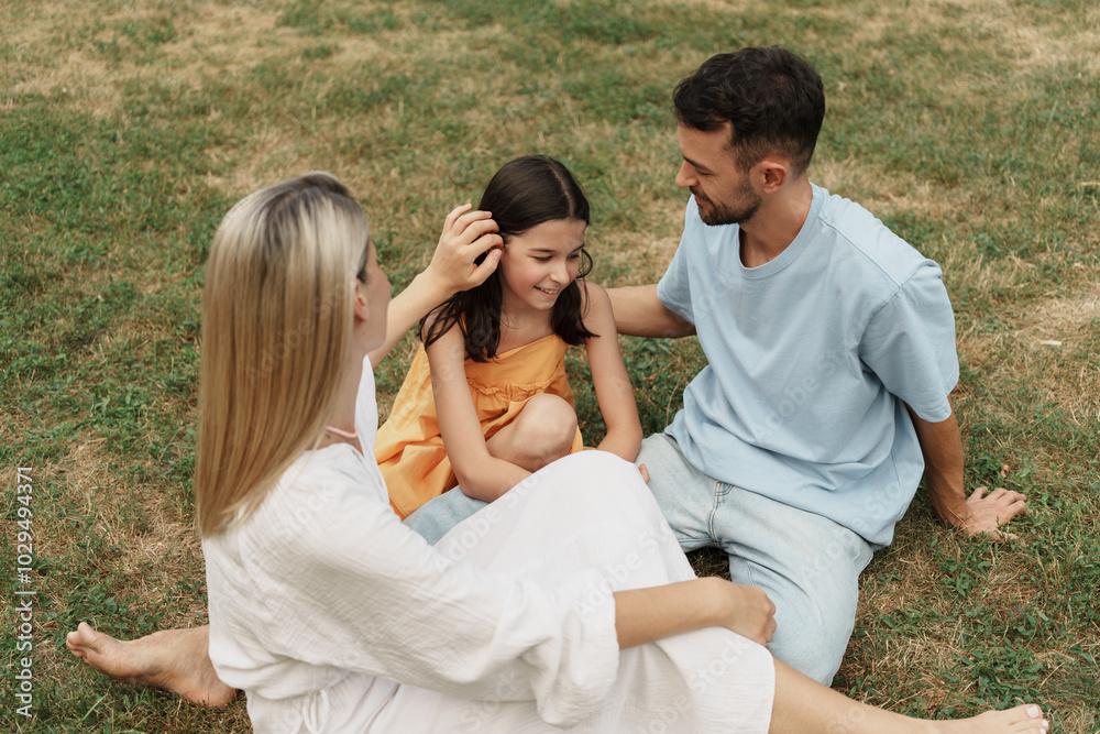 Family bonding outdoors sitting on grass enjoying a sunny day together. Family bonding outdoors sitting on grass enjoying a sunny day together.