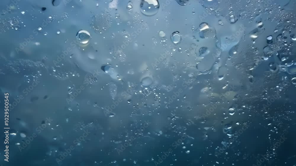 Capturing stunning water droplets forming abstract patterns against a vibrant blue background. Delicate texture and liquid nature create a captivating visual