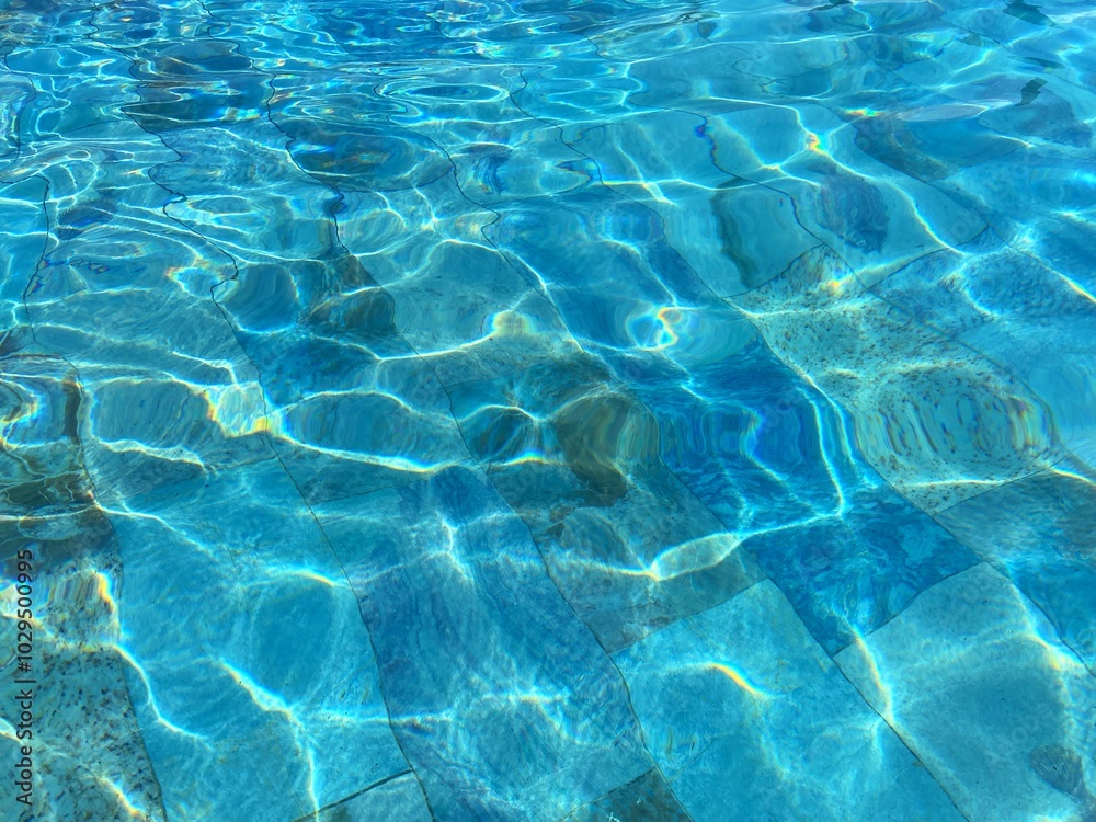 Obraz premium The water in the pool shimmers in the sun. The blue texture of the pool water