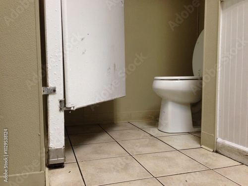 toilet in a bathroom with the stall door open photo