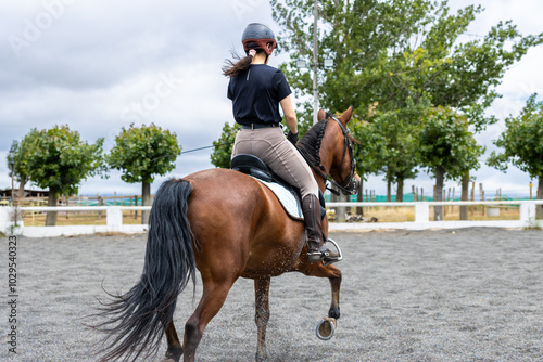 girl riding brown horse in equestrian practice