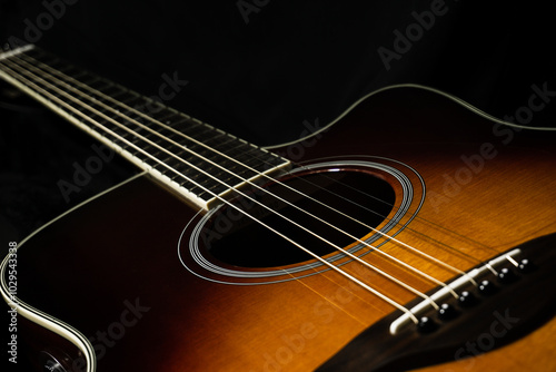 Acoustic guitar on black background, sunbrust body acoustic guitar parts close up,  plucked instrument, shallow depth of field part of a acoustic guitar, guitar chords, playing music