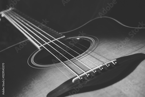 Acoustic guitar on black background, sunbrust body acoustic guitar parts close up,  plucked instrument, shallow depth of field part of a acoustic guitar, guitar chords, playing music, black and white