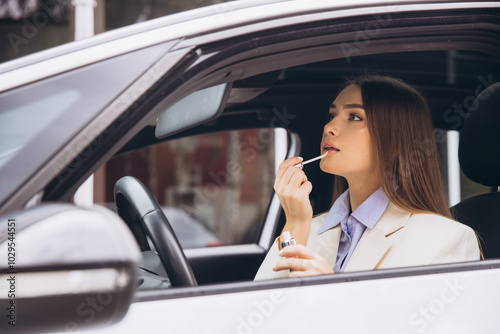 Woman Applying Lipstick While Sitting in a Car