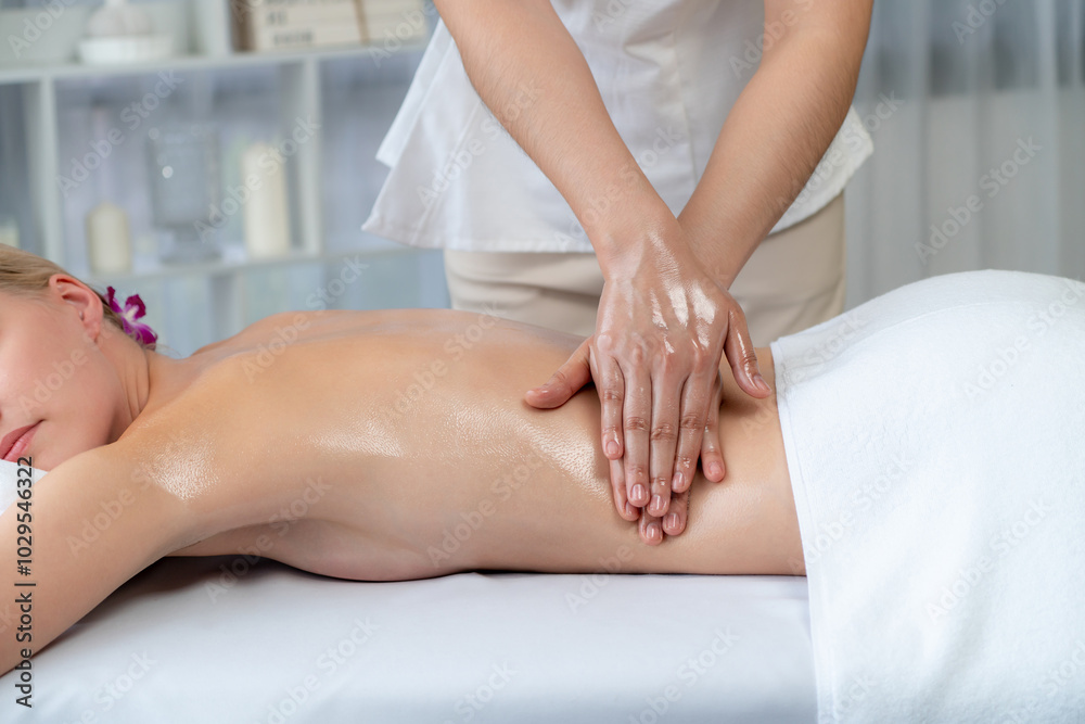 Fototapeta premium Caucasian woman customer enjoying relaxing anti-stress spa massage and pampering with beauty skin recreation leisure in day light ambient salon spa at luxury resort or hotel. Quiescent