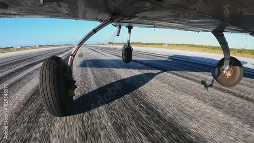 Light three wheels airplane performs take off for a training flight. Smooth lift off and slow climb. View from the bottom of aircraft.