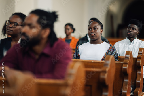 Canvas Print Young woman sitting in church pew with congregation listening to sermon