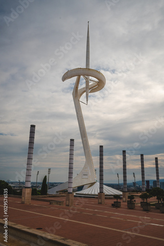 A view of the modern telecommunications tower in Barcelona against a cloudy sky during late afternoon