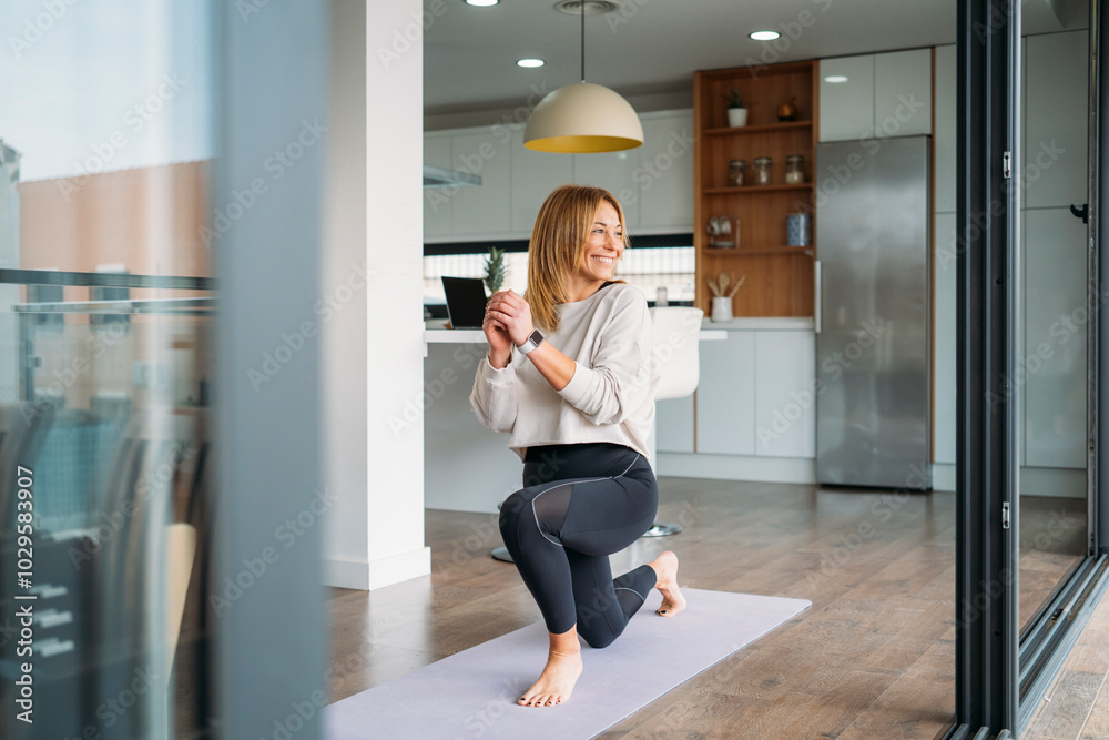 Woman Smiling While Stretching on Yoga Mat in Kitchen Woman Smiling While Stretching on Yoga Mat in Kitchen