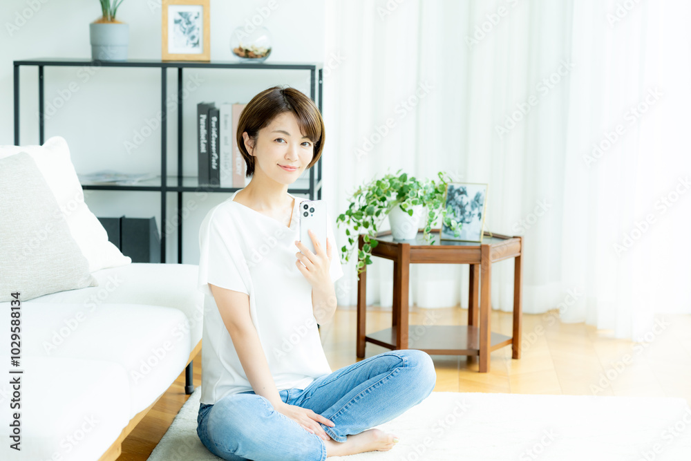 リビングでスマホを操作する女性