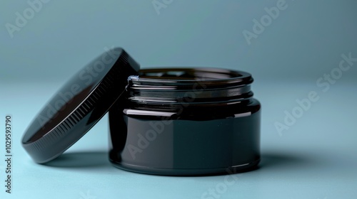 A black jar with a lid, likely for cosmetic or skincare products.