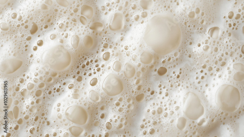 a close-up, top-down view of smooth, fine soap bubbles covering the entire surface in a soft, even layer