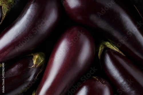 Foto Fresh Ripe Eggplants Arranged on Dark Background, Vegetable Harvest Concept, Top
