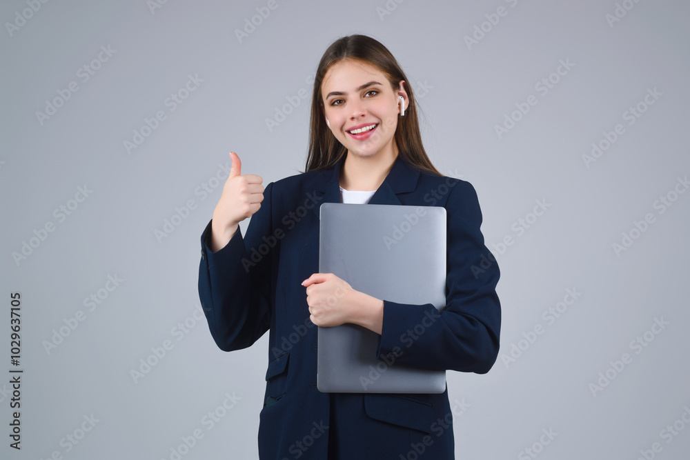 Business woman with laptop , studio portrait. Young Businesswoman holding laptop, isolated on gray. Attractive girl 20s wearing jacket working on laptop pc computer. Business on laptop. Business woman with laptop , studio portrait. Young Businesswoman holding laptop, isolated on gray. Attractive girl 20s wearing jacket working on laptop pc computer. Business on laptop.