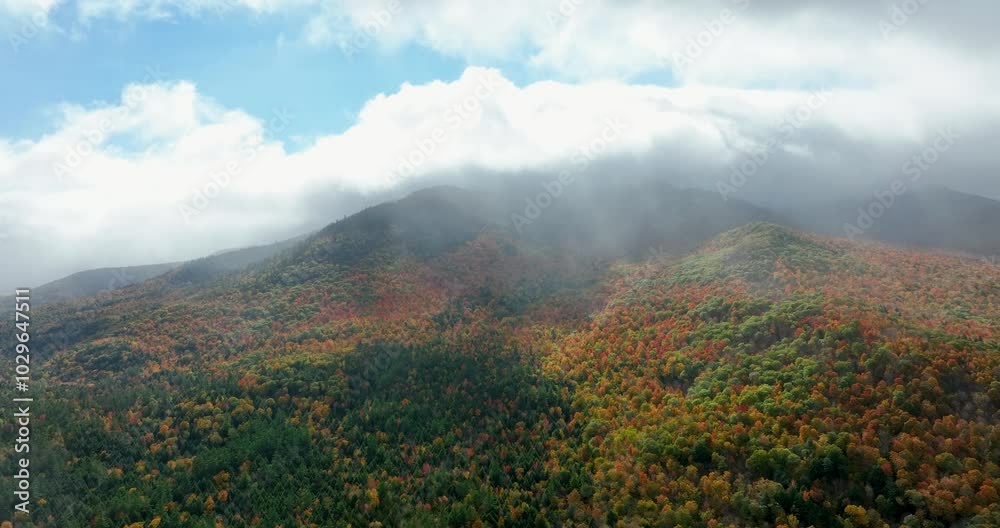 Sunlight breaks through drifting clouds over a vibrant autumn mountain, showcasing the beauty of God's creation in nature's radiant colors and serene, peaceful landscape. Sunlight breaks through drifting clouds over a vibrant autumn mountain, showcasing the beauty of God's creation in nature's radiant colors and serene, peaceful landscape.