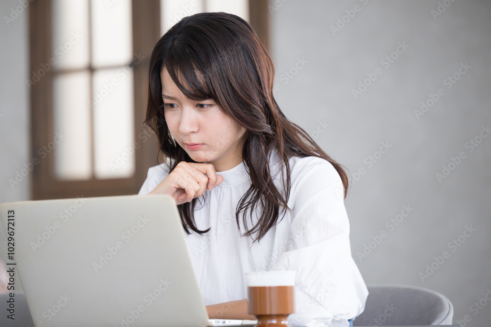 Profile of a troubled young woman thinking while looking at a computer. Profile of a troubled young woman thinking while looking at a computer.