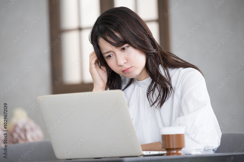 パソコンを見ながら考える困る若い女性の横顔 パソコンを見ながら考える困る若い女性の横顔