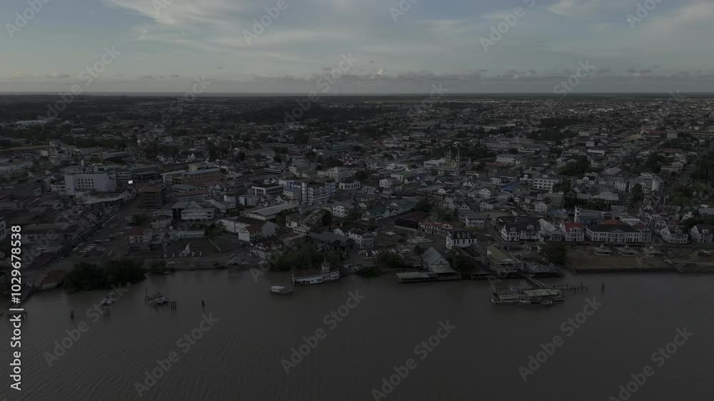 Drone flies to the right over the Suriname River overlooking the historic city center at sunset in Paramaribo, Suriname Drone flies to the right over the Suriname River overlooking the historic city center at sunset in Paramaribo, Suriname