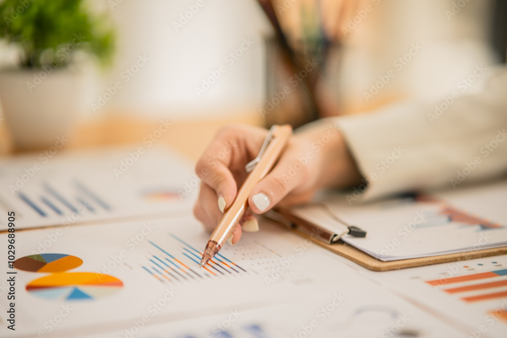 Asian woman Work on organizing graph documents to offer work Asian woman Work on organizing graph documents to offer work