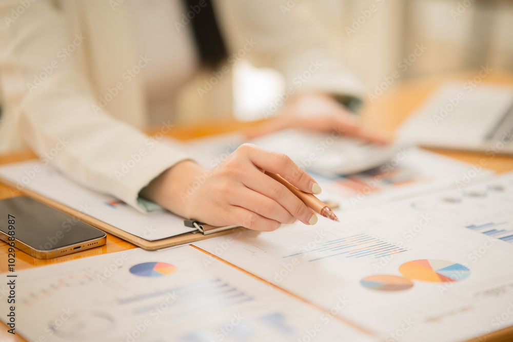 Asian woman Work on organizing graph documents to offer work Asian woman Work on organizing graph documents to offer work