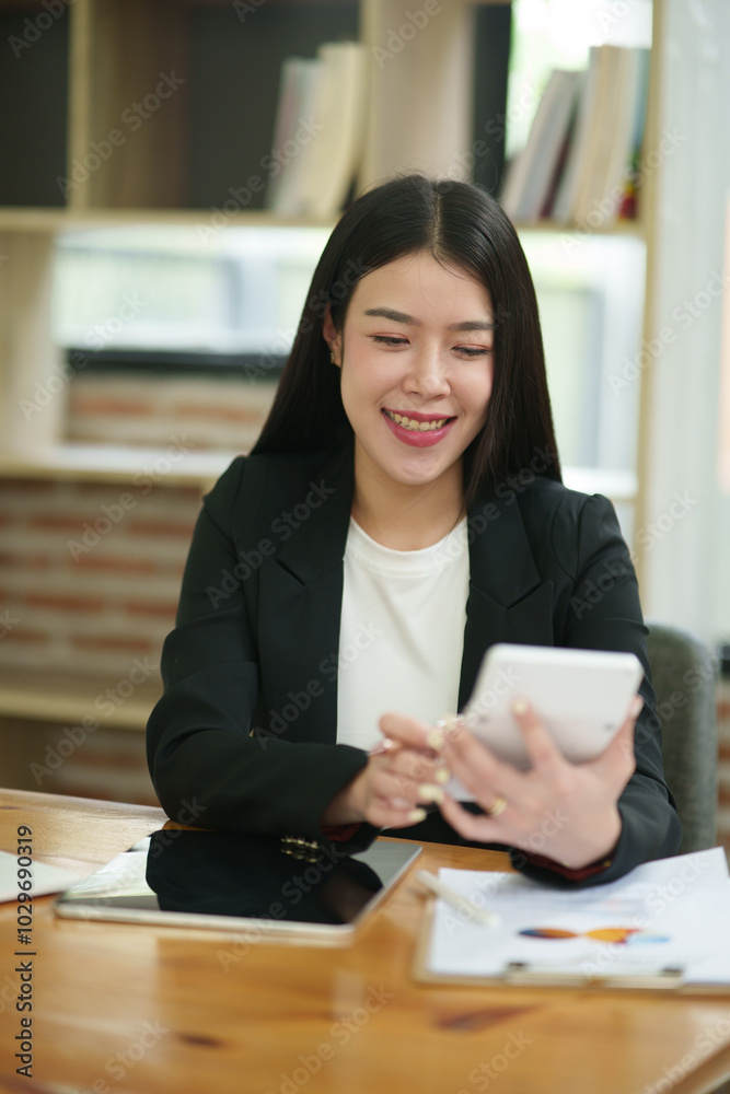 Asian business woman Use a calculator or laptop to make an accounting of income and expenses. Monthly expenses Asian business woman Use a calculator or laptop to make an accounting of income and expenses. Monthly expenses