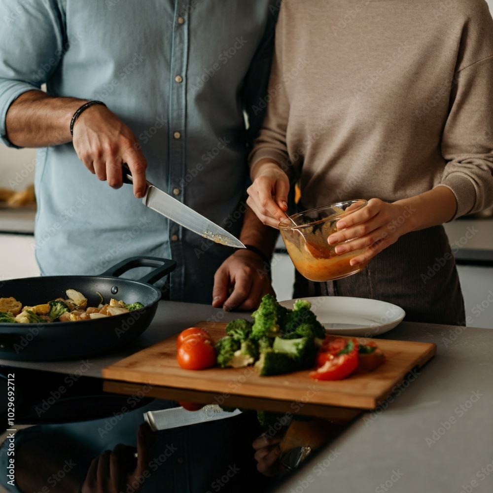 Couple cooking dinner together in a modern kitchen Couple cooking dinner together in a modern kitchen