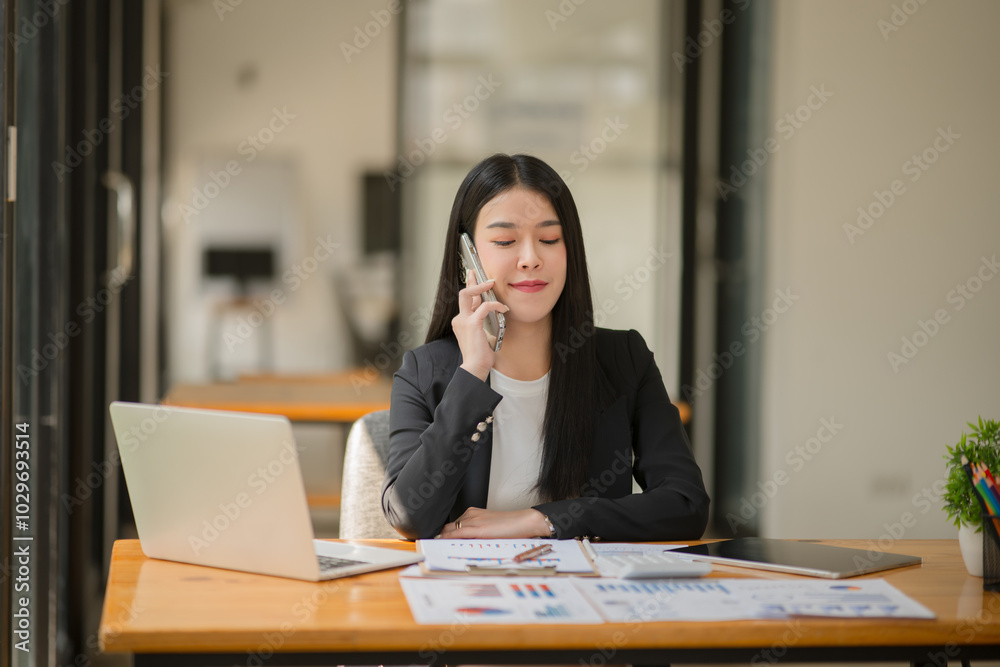 Asian business woman working and talking at the office
Asian business woman working and talking at the office