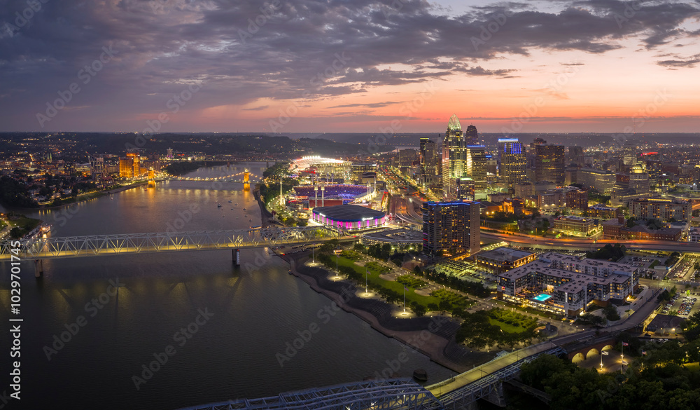 Fototapeta premium Aerial view of downtown district highway traffic in Cincinnati city, Ohio at night. Brightly illuminated high skyscraper buildings in modern American midtown