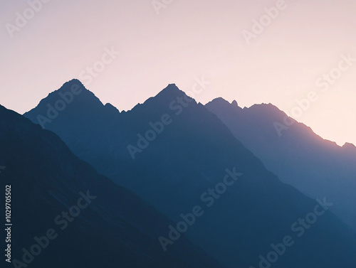 silhouette of mountain range at sunset in blue and pink hues