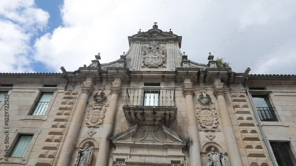 Ornate historic building with intricate stone carvings under a cloudy sky, low angle view
