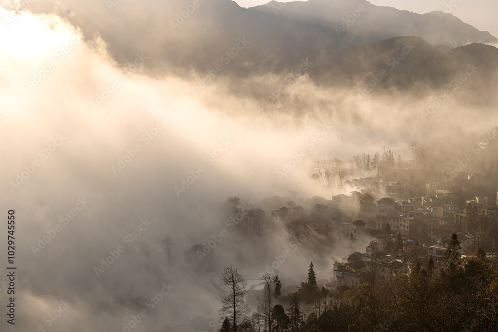 Beautiful sunrise light and the village covered by the morning fog in Yuanyang Beautiful sunrise light and the village covered by the morning fog in Yuanyang