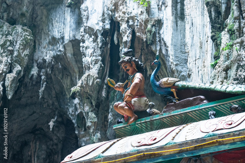Canvas Print Colorful hindu deity statue sitting on a temple roof at the batu caves in kuala